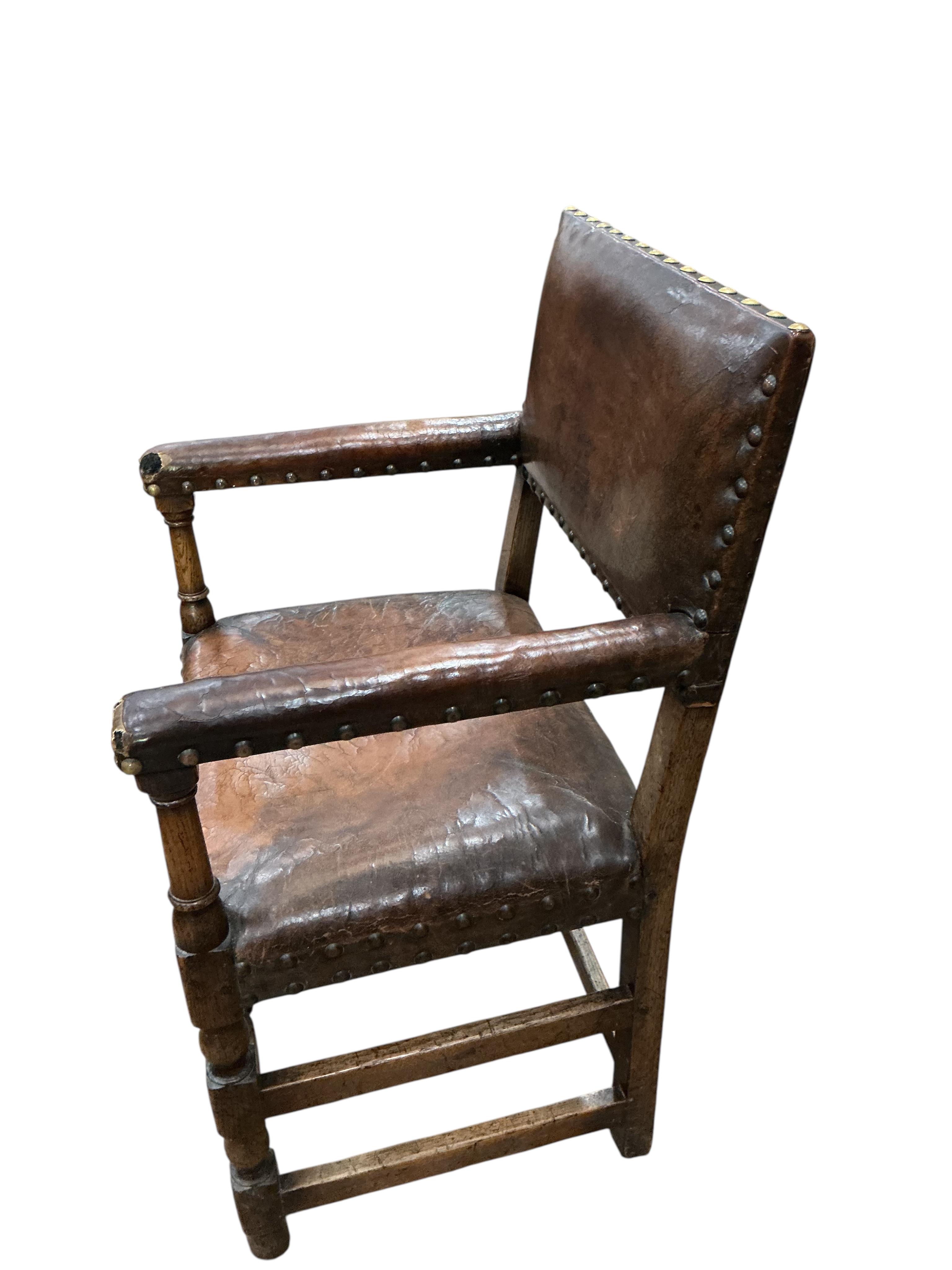 A set of eight Cromwellian style oak and tan leather dining chairs, two with arms